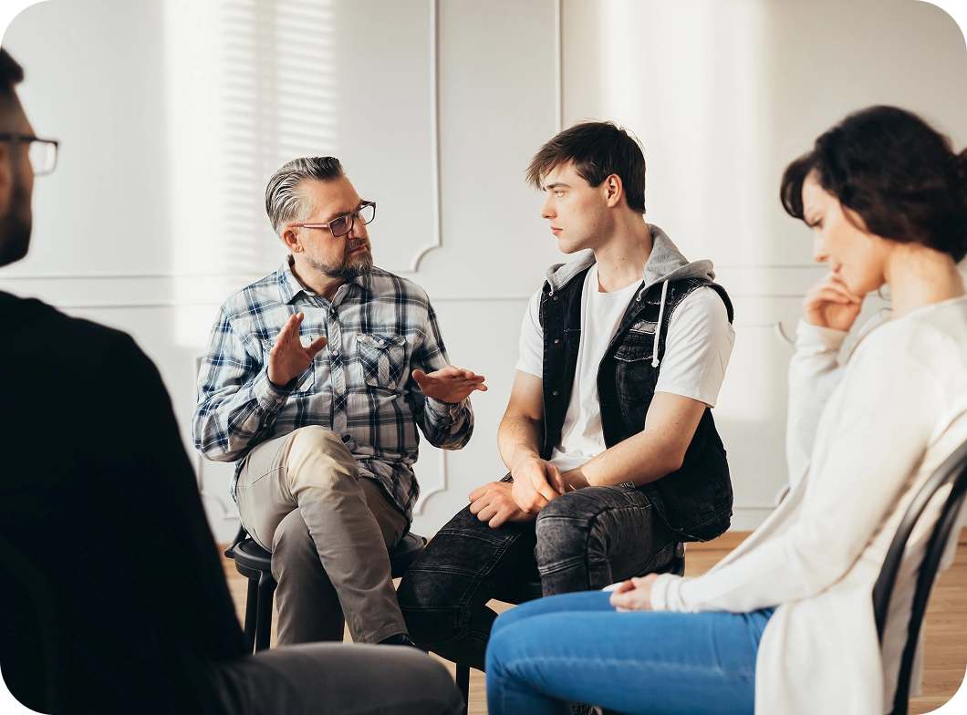 A group of people sitting in a circle talking.